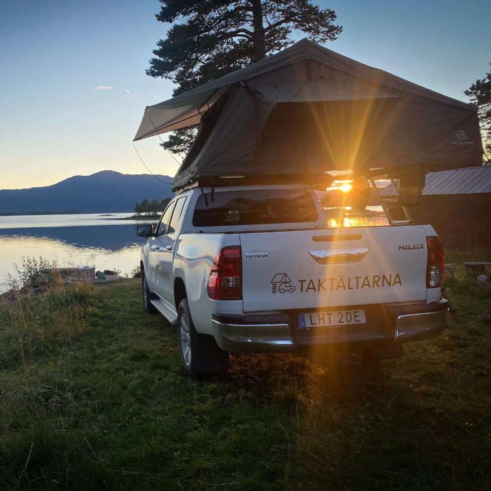 Taktältet Åreskutan från Taktältarna på en pickup stående vid en sjö i solnedgången monterad på biltaket